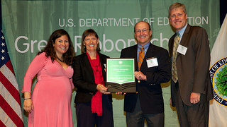 Photo of Dr. Nanette Chadwick and Mike Kensler accepting the US Department of Education Green Ribbon Schools Award from Department of Education officials.