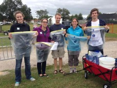 Photo of Office of Sustainability interns and staff handing out recycling bags and Green Game buttons to tailgaters. From left to right: Rebecca Oliver, Amy Strickland, Taylor Craft, Jennifer Morse, and Kyle Kimel.