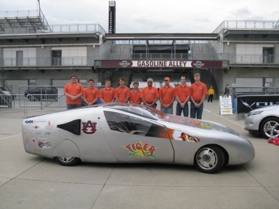 Photo of Dr. Sushil Bhavnani (fourth from right) with the TIGER car student team at the Indianapolis Motor Speedway.