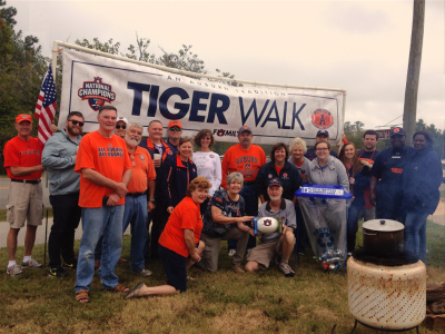 Tailgaters pose with the Gus Malzahn signed football they won by getting caught recycling at their tailgate.
