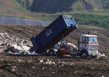 Photo of dump truck unloading at a landfill.