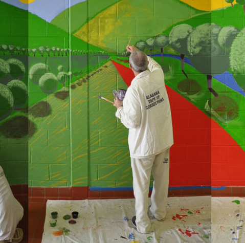 man in prison painting mural: Photo courtesy of College of Architecture, Design, and Construction