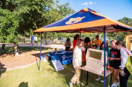 Students visiting the Auburn Bee Lab tent