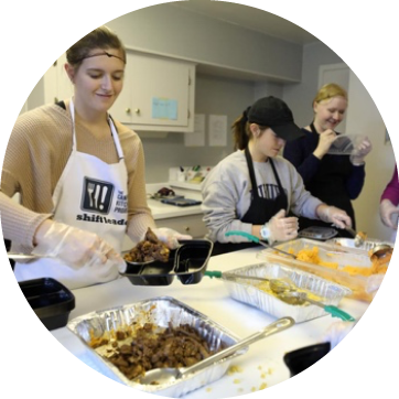 Image of students volunteering to serve food