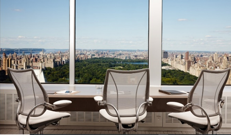 Ergonomic Humanscale brand chairs in front of a window overlooking a city