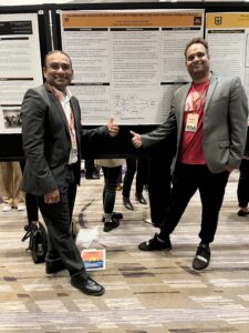 Two people in front of a presentation canvas.