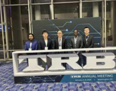 Five people standing behind a desk in a conference