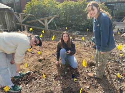 Three people smiling in the soil.