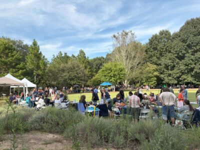 Photo of picnic goers visiting the tables of participating organizations.