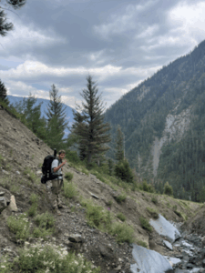 A man in backpacking gear walking on a mountain trail