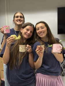 three girls with decorated mugs with plants in them.