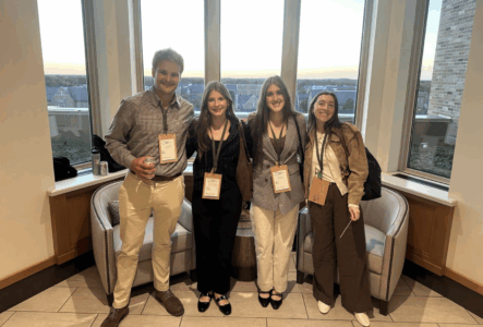 4 student interns posed to show off their wooden, reuseable nametags.