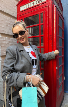 a girl standing in front of a vintage red telephone booth
