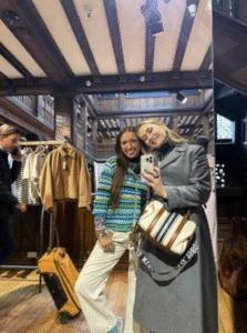 two girls taking a mirror selfie inside of a clothing store