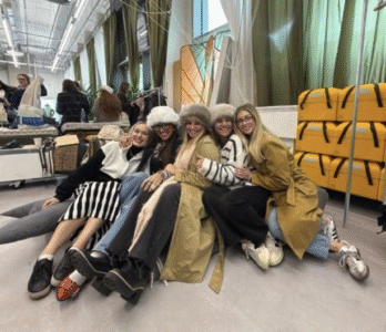 5 girls hugging and posing for a photo in a fashion warehouse