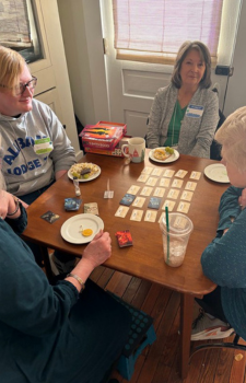 4 people, 2 younger, 2 older, playing a game at a table
