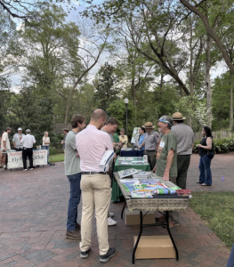 three tables in a row of organizations talking to attendees