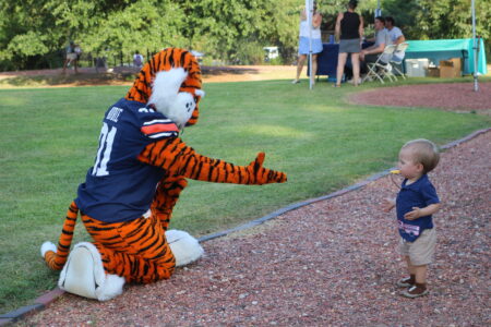 aubie reaching out his hand at a child