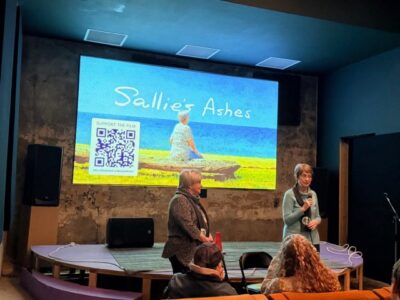 two women infront of a screen that says sallie's ashes